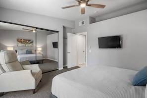 A bedroom with a bed, a chair, a television, and a ceiling fan. - Mesquite Modern Dream (Palm Springs)