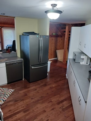 A compact kitchen with a refrigerator, dishwasher, and microwave.