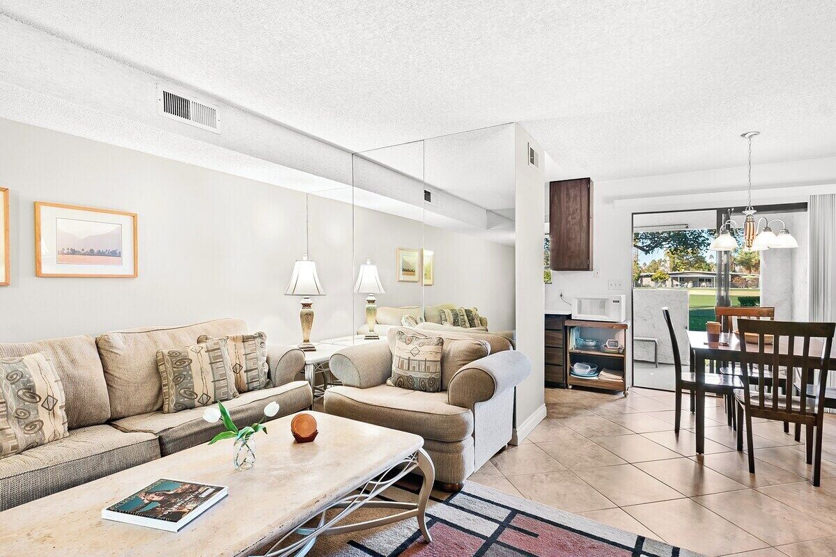 A modern living room with a sofa, coffee table, and dining area.