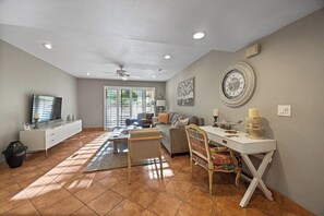 A spacious living room with a sofa, coffee table, and a TV. - Canyon Granada Hideaway (Palm Springs)