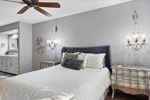 A bedroom with a bed, a dresser, a ceiling fan, and wall sconces. - Canyon Granada Hideaway (Palm Springs)