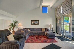 A modern living room with a sectional sofa, a coffee table, and a large window. - Cathedral Canyon CC Oasis (Palm Springs)