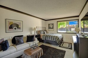 A bedroom with a bed, a sofa, a desk, and a window. - Cathedral Canyon CC Oasis (Palm Springs)