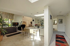 A modern living space with a dining area, kitchen, and a TV in the living room. - Cathedral Canyon CC Oasis (Palm Springs)