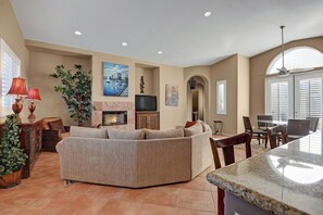 A living room with a fireplace, seating area, and dining space. - Hidden Jewel at Rio Del Sol (Cathedral City)
