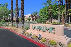 Schild mit 'LAPALME', das auf ein Hotel- oder Resortgebiet mit Palmen und blauem Himmel hinweist.