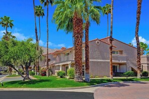 A multi-story hotel with a symmetrical facade, palm trees, and a well-maintained lawn. - Mesquite Getaway - 2BR Condo with Pool and Views (Palm Springs)