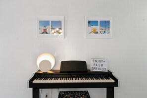 A piano with a light fixture and a sign that reads 'ENJOY PALM SPRINGS.' - Canyon Country Club Chic (Palm Springs)