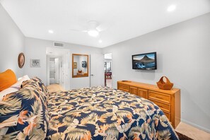 A bedroom with a bed, a dresser, a television, and a door leading to another room. - Estados Sanctuary - South Palm Springs (Palm Springs)
