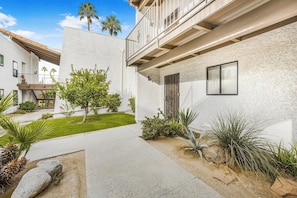 A modern two-story building with a balcony, a well-maintained garden, and a clear sky. - Estados Sanctuary - South Palm Springs (Palm Springs)