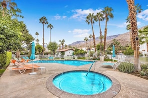 A swimming pool area with lounge chairs and umbrellas, surrounded by palm trees and a mountain backdrop. - Estados Sanctuary - South Palm Springs (Palm Springs)
