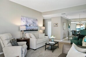A living room with a sofa, armchairs, a coffee table, and a painting on the wall. - La Palme Urban Chic Palm Springs Condo (Palm Springs)