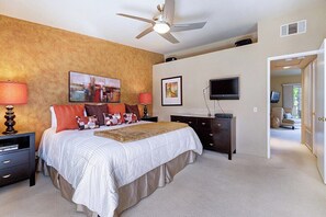 A bedroom with a bed, nightstands, a dresser, a ceiling fan, a television, and a painting on the wall. - Mesquite Comfort Phase 2 (Palm Springs)