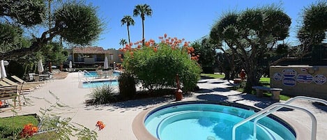 A swimming pool area with lounge chairs and a building in the background.
