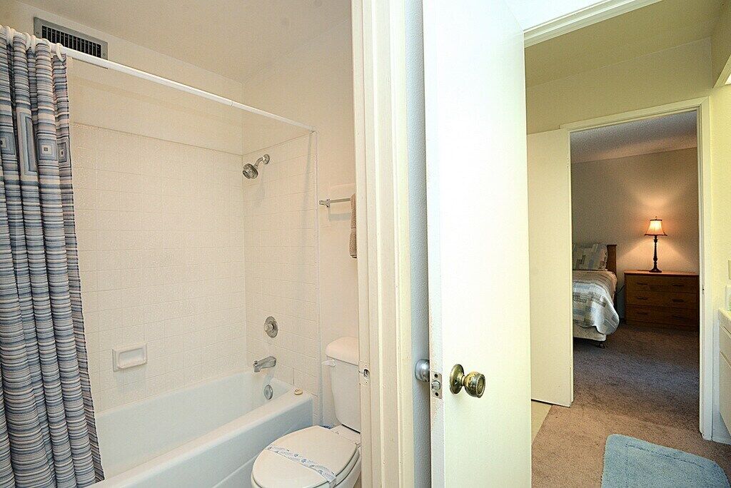 Un baño con bañera, inodoro y cortina de ducha.