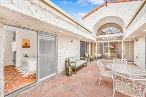 A courtyard with a seating area, a table, and chairs. - Araby Luxe by Design (Palm Springs)