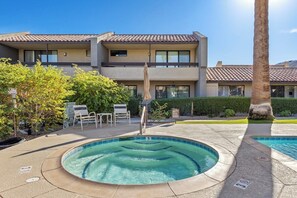 A swimming pool with a hot tub, surrounded by a patio area with chairs and a palm tree. - Midtown Mountain View Villa (Palm Springs)