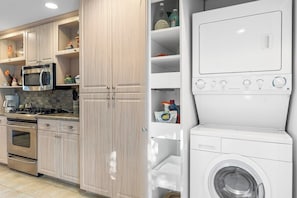 A modern kitchen with stainless steel appliances, wooden cabinets, and a built-in washer and dryer. - Midtown Mountain View Villa (Palm Springs)