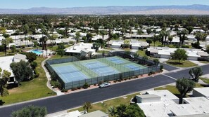 Ein Wohngebiet mit Tennisplatz, Häusern und einer Straße.
