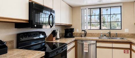 A kitchen with a stove, microwave, and dishwasher.
