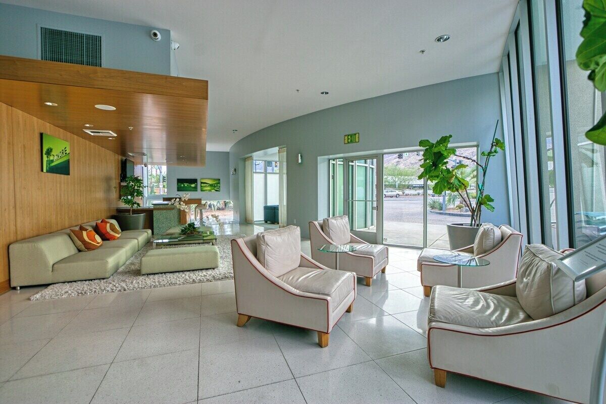 A modern lobby with a sofa, armchairs, and a coffee table.