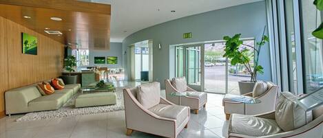 A modern lobby with a sofa, armchairs, and a coffee table.