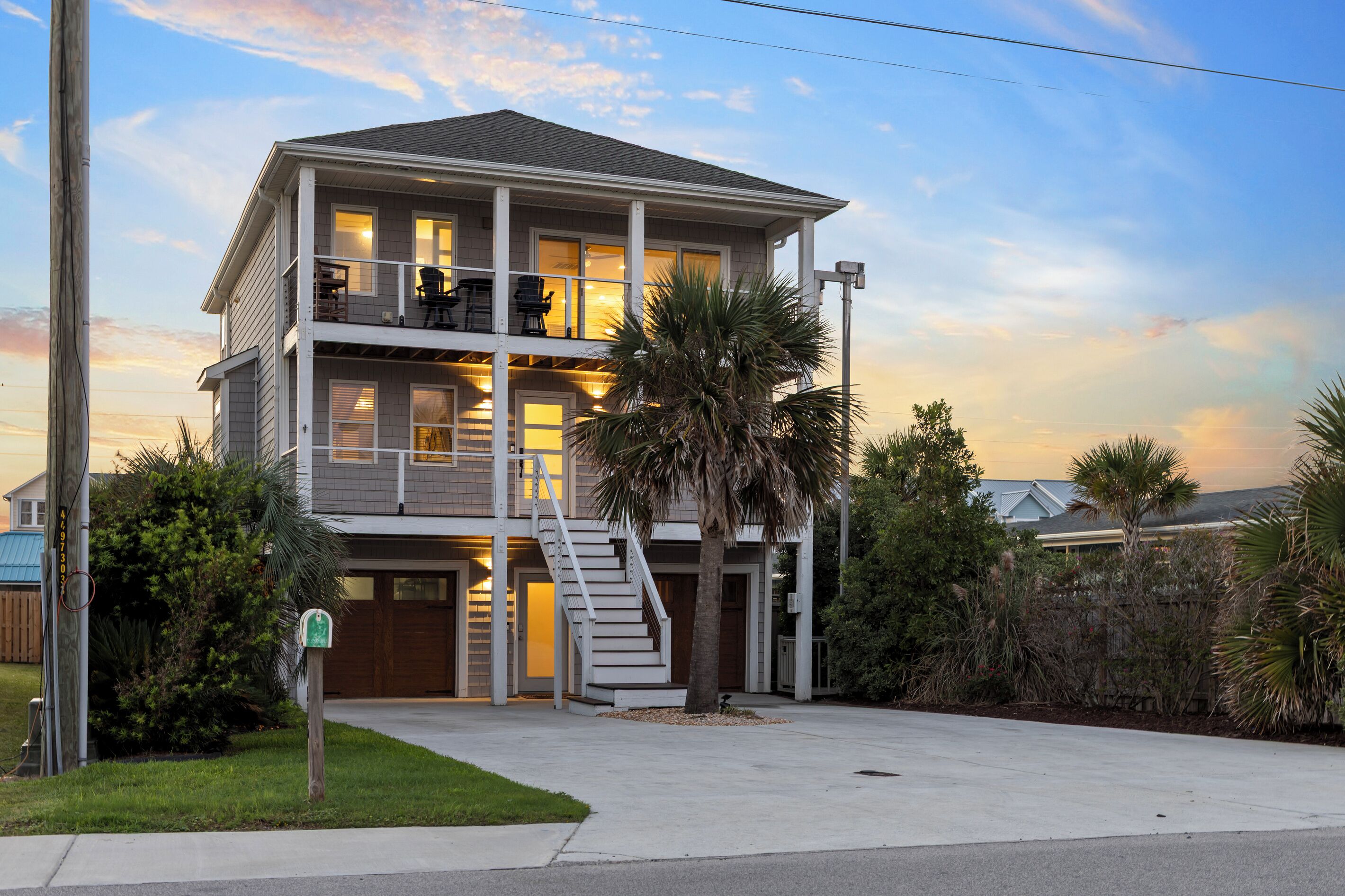 A two-story residential building with a balcony on the upper floor and a staircase leading to the entrance.
