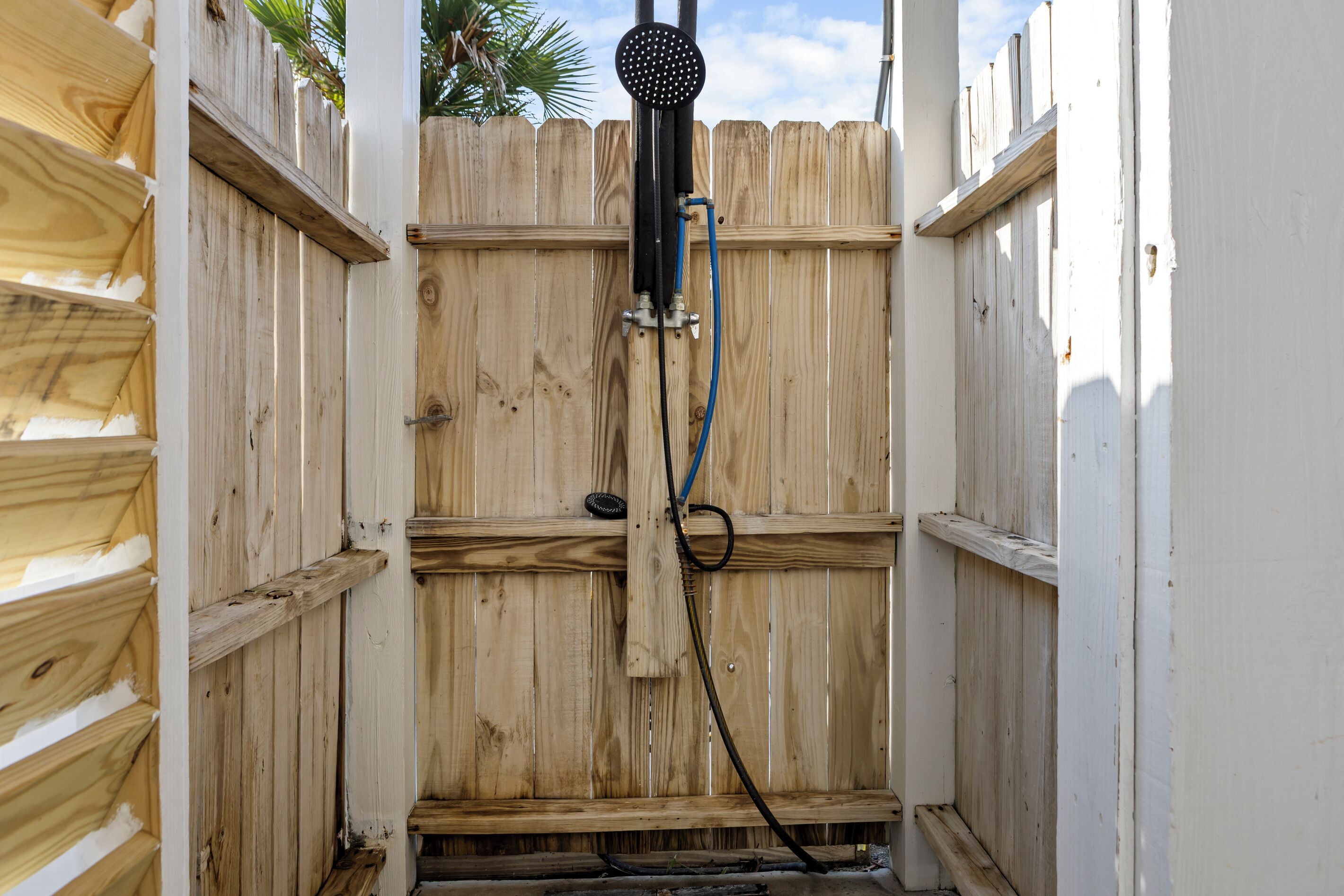 A wooden fence with a black object mounted on it, possibly a security device.