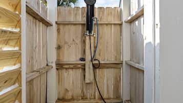A wooden fence with a black object mounted on it, possibly a security device.