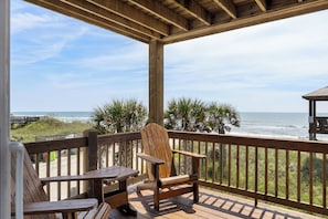 A wooden deck with a view of the ocean and beach, featuring a wooden chair and table. - Oceanfront | Private Boardwalk | Gazebo (North Topsail Beach)