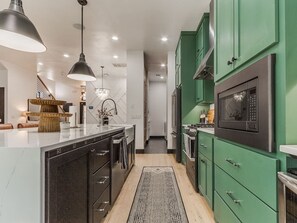 Una cocina moderna con una isla central, electrodomésticos integrados y vistas al área de estar.