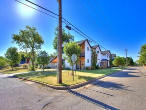 A residential street with houses, a clear sky, and a stop sign. - Chic Crown Heights Retreat W/ Fire Pit, Near Paseo (Oklahoma City)