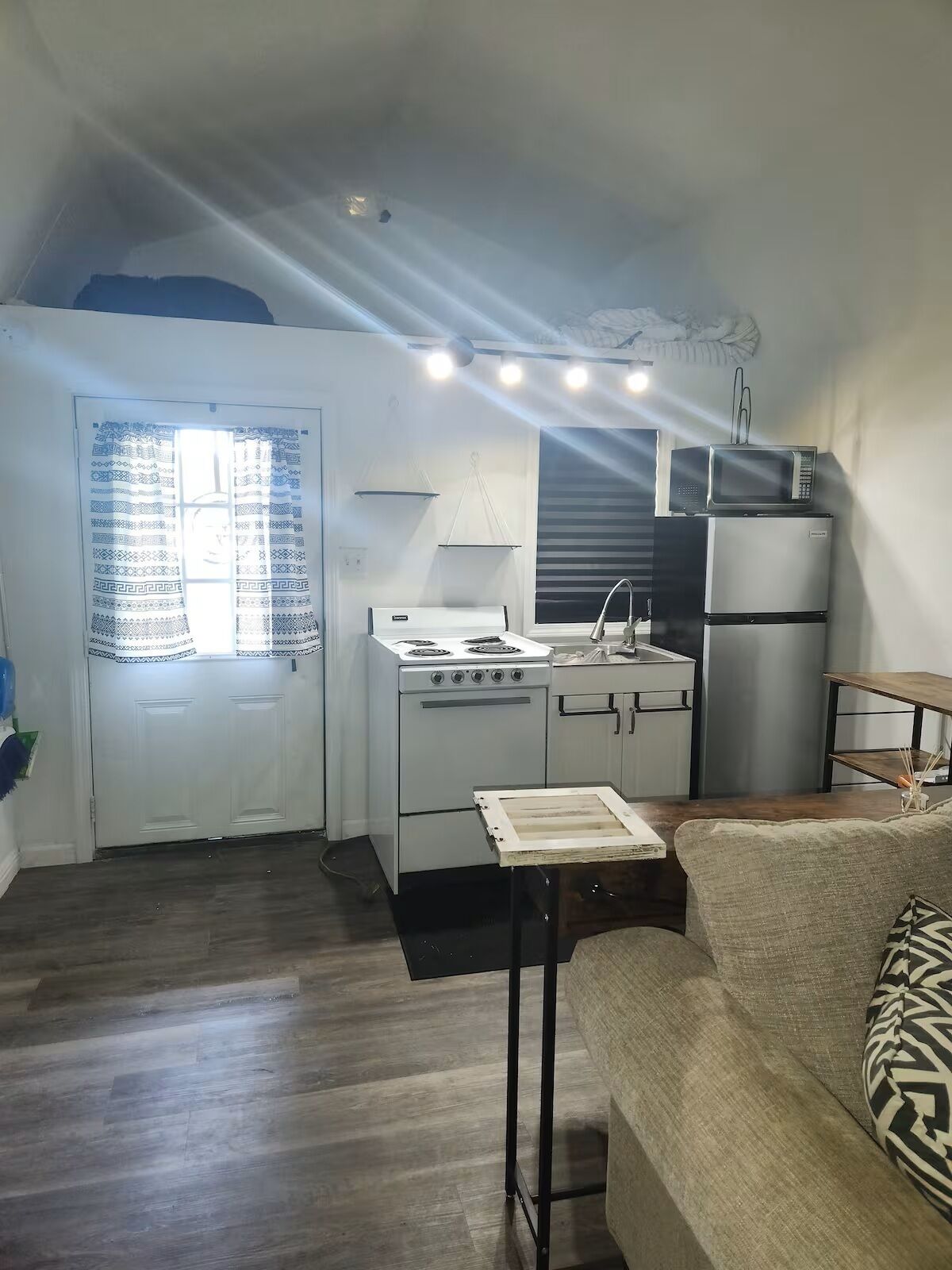 A compact kitchen with a stove, sink, and refrigerator.