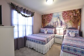 Un dormitorio con dos camas, una mesita de noche y un aparador.