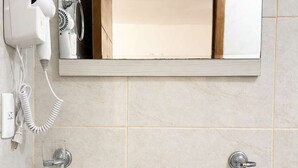 A bathroom with a white sink, a mirror, a hairdryer, and a towel rack. - BOWRA SUITE PRIVADA 1, COLONIA AMERICANA (Guadalajara)