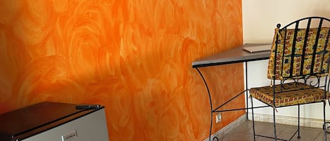 A room with a refrigerator, a chair, and a tiled floor.