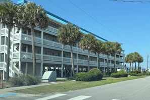A multi-story hotel with balconies, palm trees, and a clear blue sky. - NEW! Surf City 2BR Beach Escape Walk Everywhere Labor Day Available (Surf City)