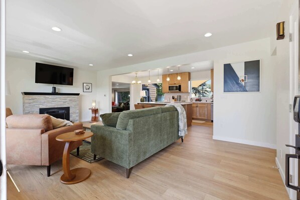 A modern living room with a fireplace, a television, and a sofa.