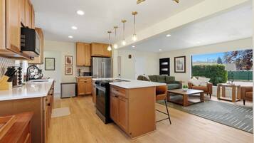 A modern kitchen with wooden cabinets, a stainless steel refrigerator, and a central island.