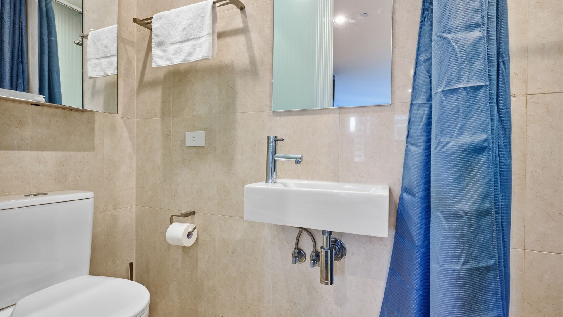 Een badkamer met toilet, wastafel en douchegordijn.