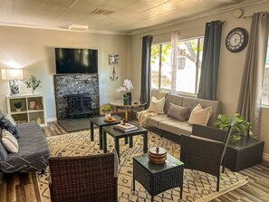 Un salon avec une cheminée, un canapé, une table basse et un téléviseur.