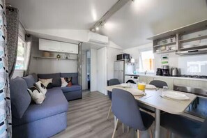 Ein kompakter Wohnbereich mit Sofa, Esstisch und Küchenzeile.