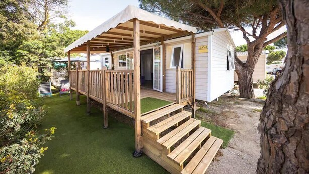 Un'abitazione mobile con una veranda in legno e un portico coperto.