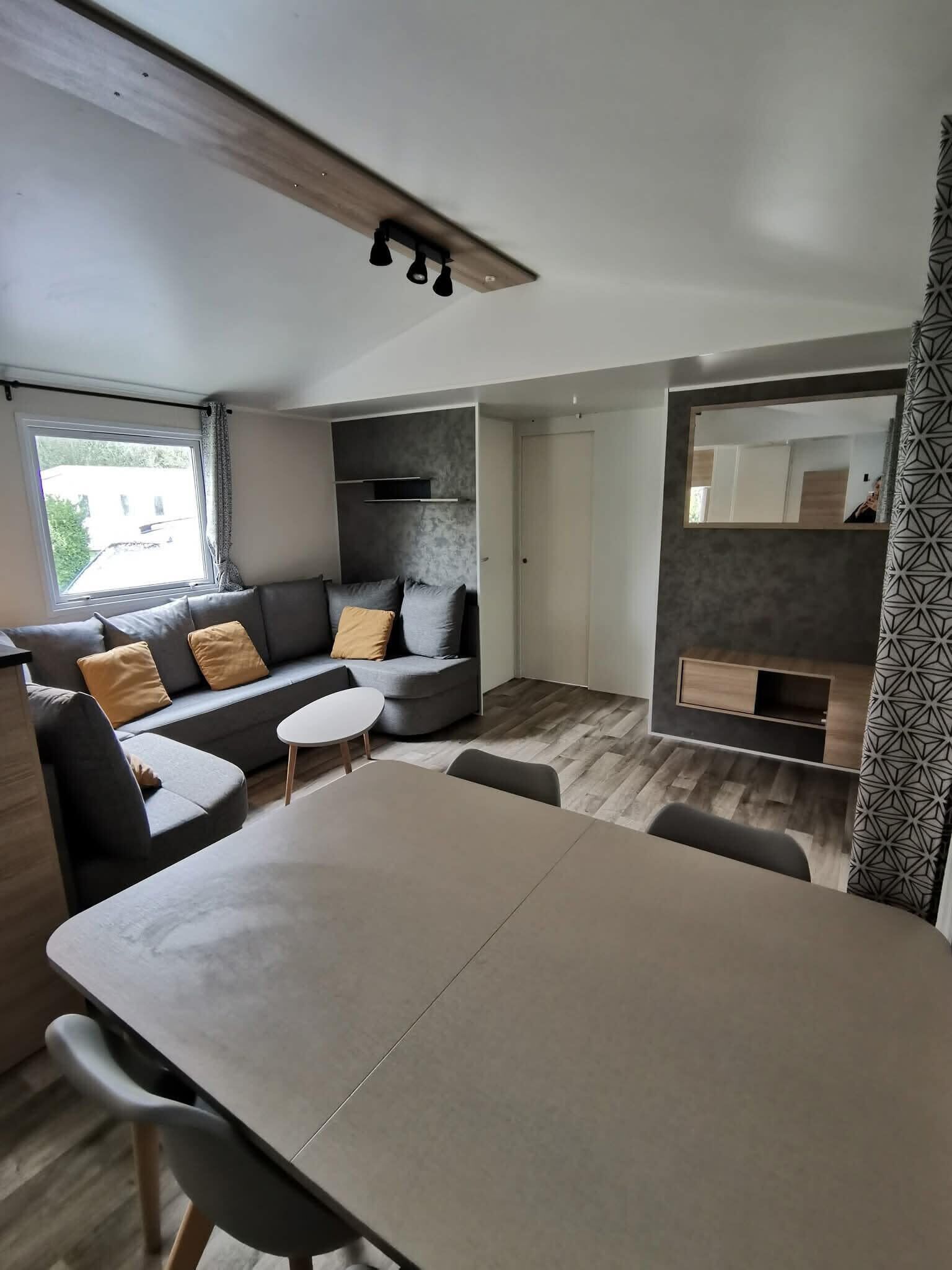 Ein modernes Interieur mit einer Couch, einem Esstisch und integrierten Regalen.