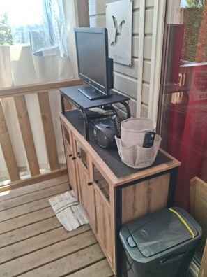 Ein Holztisch mit Fernseher, einem Aufbewahrungskorb und einem Papierkorb.