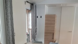 En matplats med ett bord och stolar, en trädörr och en mönstrad gardin.