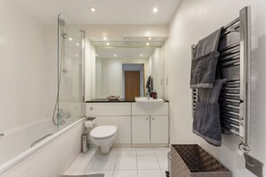 A bathroom with a glass-enclosed shower, a white toilet, a sink, and a towel rack. - Charming 1 bedroom flat in London Excel Docklands (London)