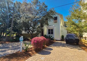 A two-story house with a paved driveway, surrounded by trees and shrubs. - Luxury Old Seagrove Retreat, Walk to Beach and Seaside, 3 King BRs, Private Heated Pool (Seagrove Beach)