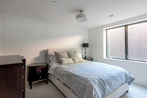 A bedroom with a bed, bedside tables, a lamp, and a window. - Modern Luxury 4-bedroom home in Boulder (Boulder)