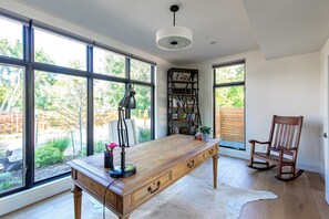 A spacious room with large windows, a wooden desk, a bookshelf, and a rocking chair. - Modern Luxury 4-bedroom home in Boulder (Boulder)